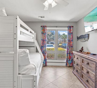 Guest bedroom with bunk beds, flatscreen TV, and peaceful lake views—great for kids or additional guests.