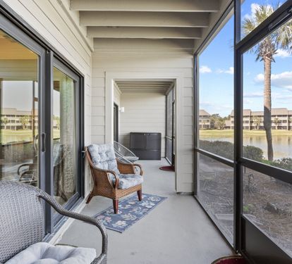 Spacious screened patio with comfortable seating and peaceful golf course and lake views.