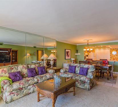Relax in your tropical-themed living space with vibrant furnishings and open dining area perfect for memorable vacation meals.