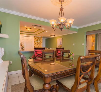 Your elegant dining space features beautiful green walls, warm chandelier lighting, and seating for memorable meals together.