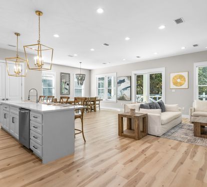 Your open-concept kitchen and living space invites you to cook, dine, and relax in style with warm wood tones and elegant lighting.