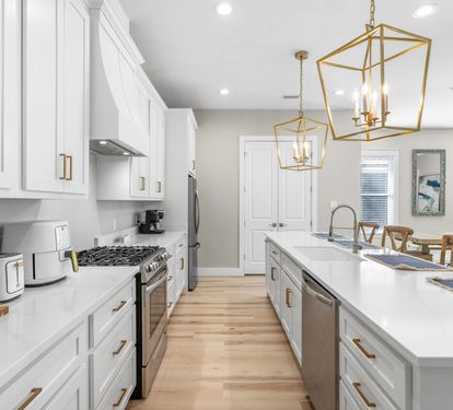 Cook memorable meals in your spacious modern kitchen with stainless steel appliances and elegant gold pendant lighting.