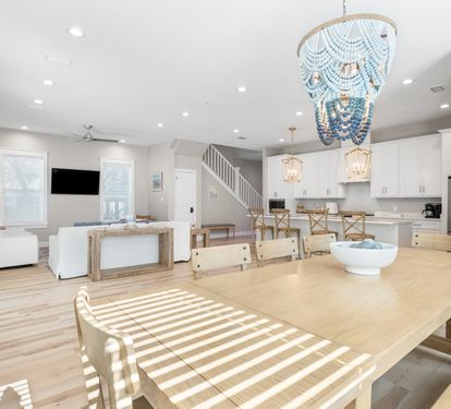 Unwind in your bright, open-concept space where coastal elegance meets comfort with designer lighting and natural wood warmth.