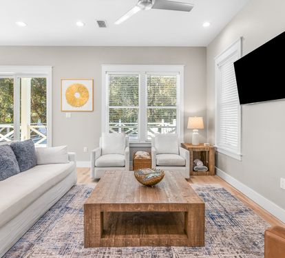 Sink into plush seating in your bright living room, where natural light streams through French doors and cozy textures invite relaxation.