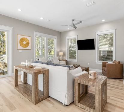 Relax in your bright living room with comfortable seating and pool views through sliding doors.