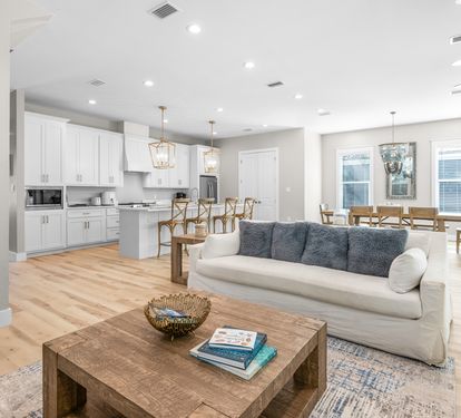 Relax in your bright open-concept space where modern comfort meets coastal charm, with soaring ceilings and natural light streaming through.
