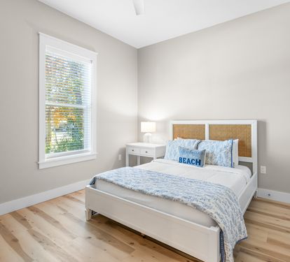Wake up refreshed in your serene bedroom with natural light streaming through the window and soft coastal touches.