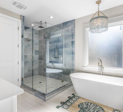 Unwind in your spa-like bathroom with a luxurious soaking tub and rainfall shower, where elegant crystal lighting creates the perfect ambiance for relaxation.