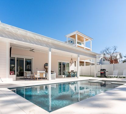 Modern coastal retreat with pristine pool and spacious covered patio for relaxing under sunny skies.