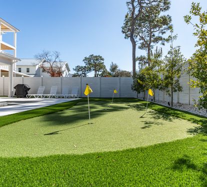 Perfect your putting game on your private artificial green, surrounded by lush landscaping and modern amenities in this bright backyard oasis.