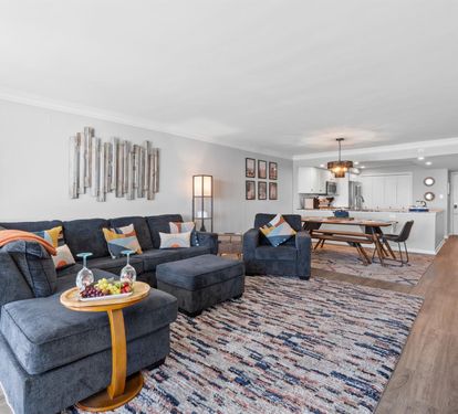 Sink into this spacious open-concept living area where comfort meets style. Your sectional sofa and colorful accents create the perfect gathering spot.