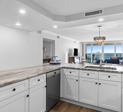 Your fully-equipped kitchen flows seamlessly into the living space, where stunning ocean views await through floor-to-ceiling windows.