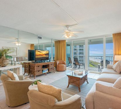 Relax in your elegant beachfront living room with floor-to-ceiling windows framing stunning ocean views and your private balcony.