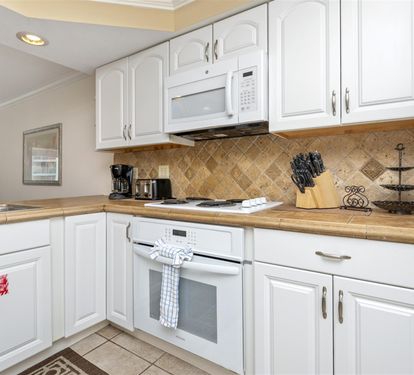 Your bright, fully-equipped kitchen invites home-cooked meals with white cabinets, granite counters, and modern appliances.