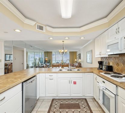 Your fully equipped kitchen features granite countertops and white cabinetry, perfect for preparing meals while overlooking the open living space.