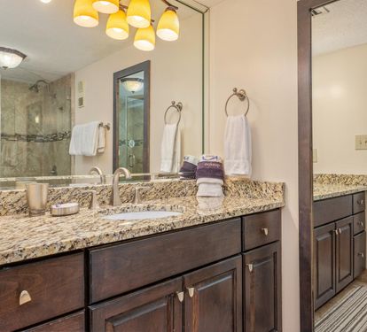Luxurious master bathroom with granite countertops, dual vanities, and elegant pendant lighting creates your perfect morning routine.