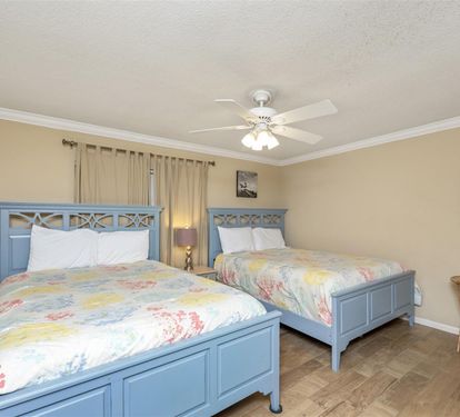 Relax in your spacious twin bedroom with charming blue beds, soft quilts, and peaceful coastal decor—perfect for restful nights.