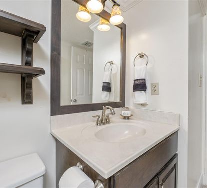 Refresh in your stylish bathroom with custom vanity, warm lighting, and plush towels ready for your arrival.