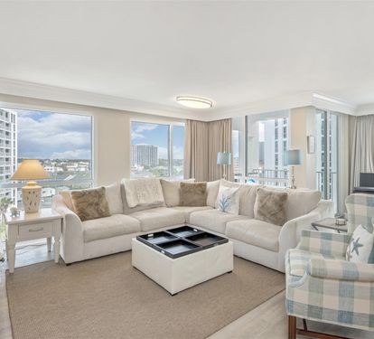 Relax in your bright living room with plush seating and stunning city views through floor-to-ceiling windows.