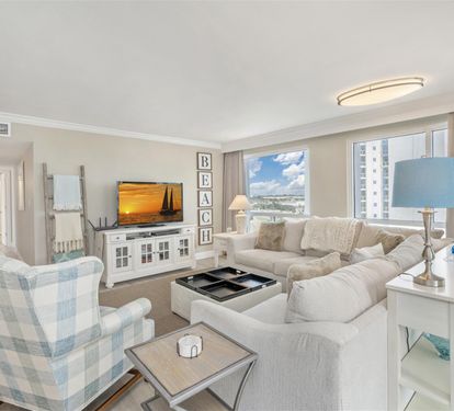 Sink into plush sectional seating while enjoying ocean views through floor-to-ceiling windows in your stylish coastal retreat.