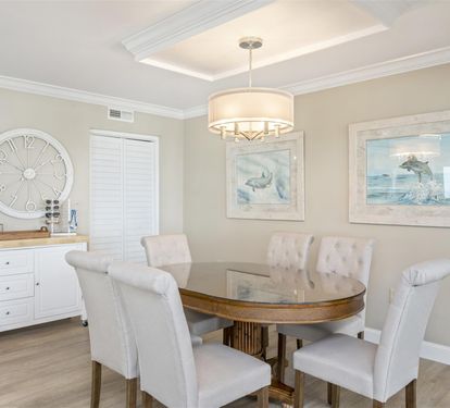 You'll love gathering around this elegant dining table with plush seating for eight, beneath sophisticated coastal artwork and warm lighting.