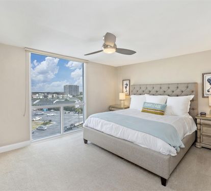 Drift off to sleep in your plush king bed while enjoying the city skyline through floor-to-ceiling windows in this serene bedroom.