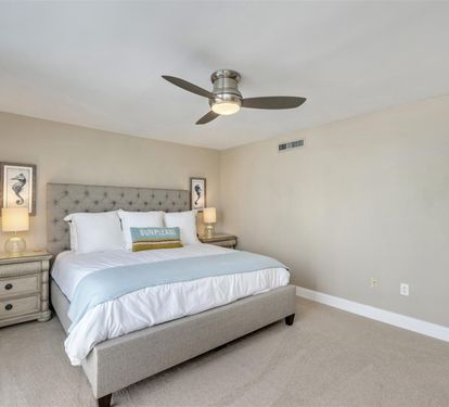 Drift into peaceful dreams in your coastal-inspired bedroom, where soft linens and gentle breezes from the ceiling fan create perfect sleeping comfort.