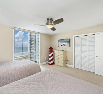 Wake up to stunning ocean views through your floor-to-ceiling windows, with twin beds and ample storage for a perfect beachside retreat.
