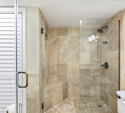 Step into your luxurious glass-enclosed shower with beautiful stone tiling and dual rainfall heads for the ultimate relaxation experience.