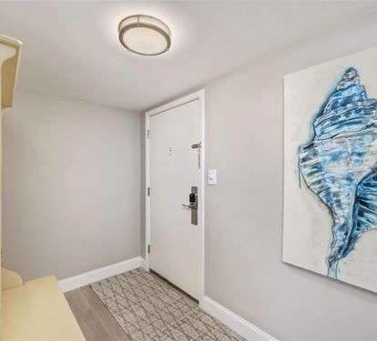 Step into your welcoming entryway where coastal artwork and warm lighting create the perfect first impression of your seaside retreat.