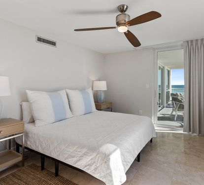Wake up to ocean breezes in your serene bedroom, where soft linens and gentle ceiling fan create perfect comfort for restful nights.