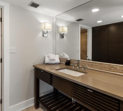 Pamper yourself in this sophisticated bathroom featuring sleek modern fixtures, elegant lighting, and plush towels awaiting your arrival.
