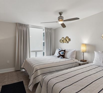 Drift off in your peaceful twin bedroom with city views, gentle ceiling fan breeze, and modern coastal touches.