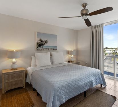 Drift off in this serene bedroom with soft coastal hues, where you'll wake refreshed beneath the gentle ceiling fan breeze.