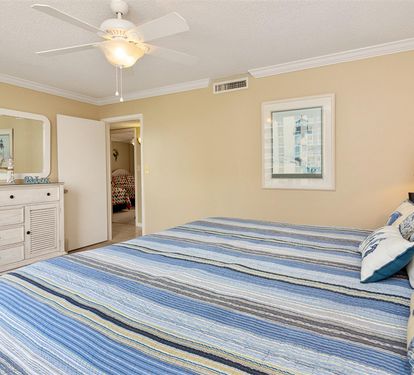 Unwind in your coastal bedroom with ocean-inspired bedding, gentle ceiling fan breeze, and nautical touches creating the perfect seaside retreat.