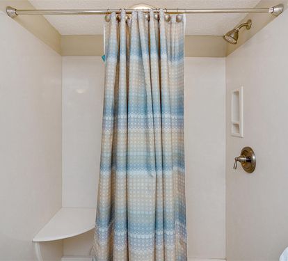 Step into your private sanctuary with a refreshing rainfall shower, soft coastal-inspired curtain, and plush towels waiting for you.
