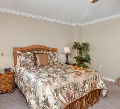 Unwind in your tropical-themed bedroom with comfortable linens and warm island-inspired décor that creates a peaceful retreat.