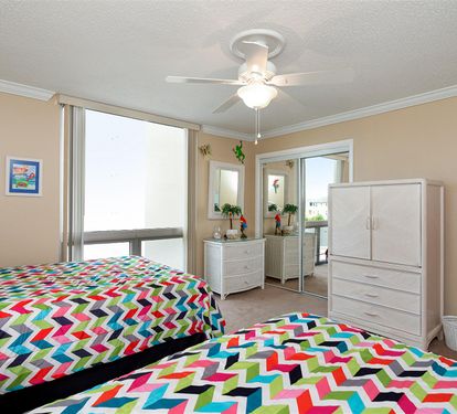 Drift off to sleep in this cheerful bedroom featuring vibrant geometric bedding and bright natural light streaming through your windows.