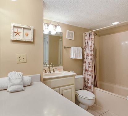 Refresh in your private bathroom with coastal charm, featuring fresh towels and a relaxing tub.