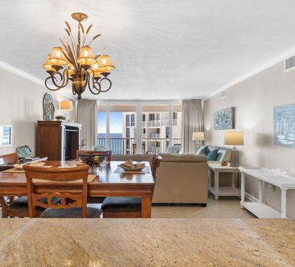 Relax in your spacious living area with elegant furnishings and ocean views through floor-to-ceiling windows.