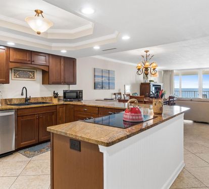 Your spacious kitchen features granite countertops, rich wood cabinetry, and an island perfect for meal prep while enjoying ocean views.