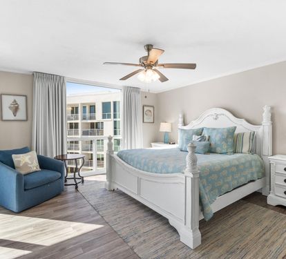 Your master bedroom retreat features elegant coastal decor, premium bedding, and balcony access with natural light streaming through.