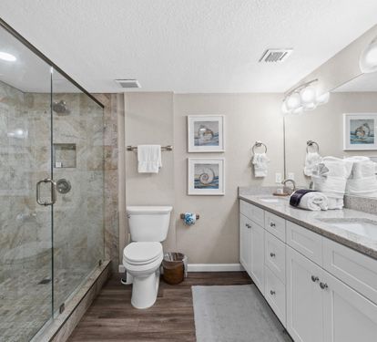 Your elegant bathroom features marble shower, granite counters, and coastal artwork creating a spa-like retreat.