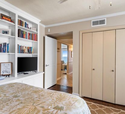 Your bedroom features built-in shelving filled with books, a flat-screen TV, and generous closet space for all your belongings.