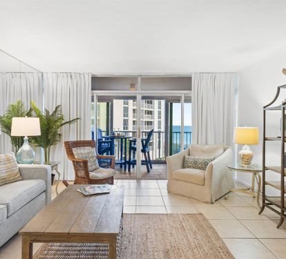 Relax in your bright coastal living room where ocean breezes flow through sliding doors to your private balcony overlooking stunning sea views.