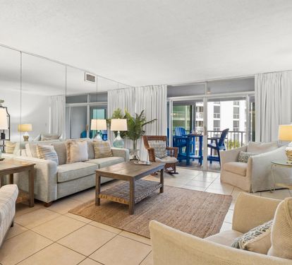 Sink into plush coastal seating in your bright, airy living room where natural light and beach-inspired decor create the perfect vacation ambiance.