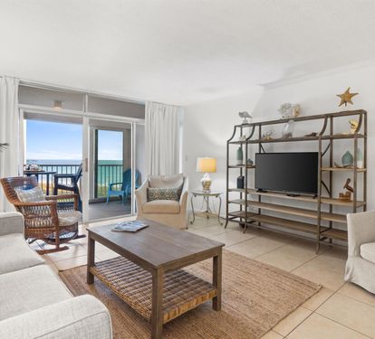 Relax in your coastal living room with comfortable seating and stunning ocean views from your private balcony.