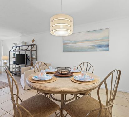 Gather around your beautifully set dining table, where coastal charm meets comfort in this bright, open living space designed for memorable meals.