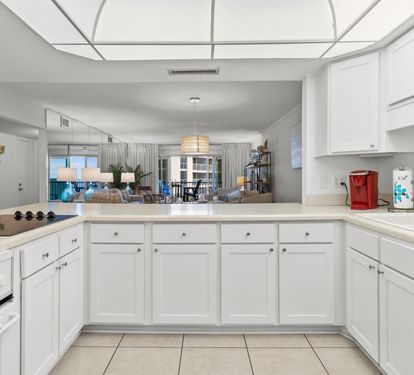 Your spacious kitchen features crisp white cabinets and modern appliances, opening to a bright living area perfect for cooking and entertaining.