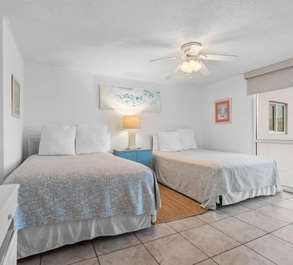 Drift off in your bright Queen bedroom with comfortable beds, coastal artwork, and refreshing ceiling fan breeze.
